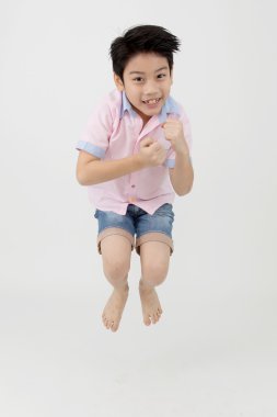 Stüdyoda mutlu Asya oğlan atlıyor.