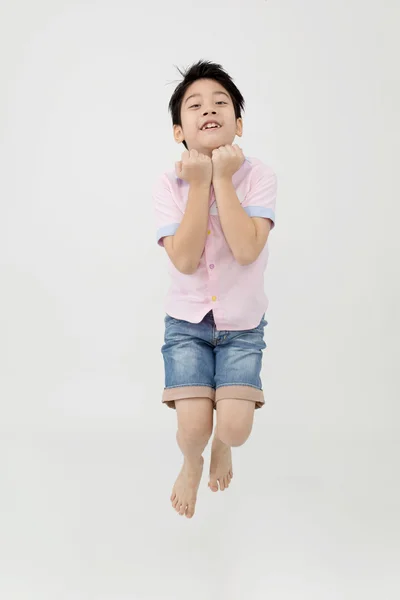 Felice asiatico ragazzo è jumping a studio . — Foto Stock