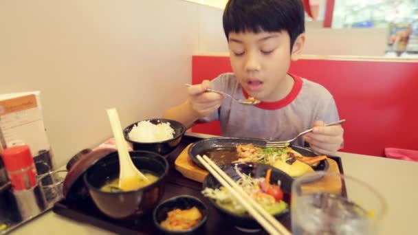 Happy asian child eating sushi in a restaurant with smile face — Stock Video