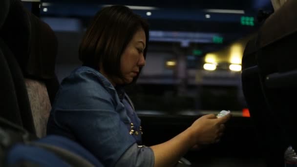 Jovem mulher asiática usando smartphone enquanto monta ônibus — Vídeo de Stock