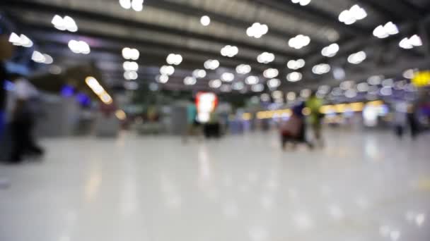 Kerumunan orang berjalan dengan bagasi di bandara internasional, adegan de-fokus  . — Stok Video