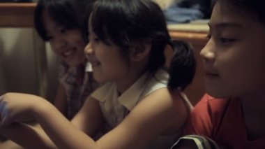 Evde dokunmatik yüzeyle oynayan asyalı bir grup çocuk .