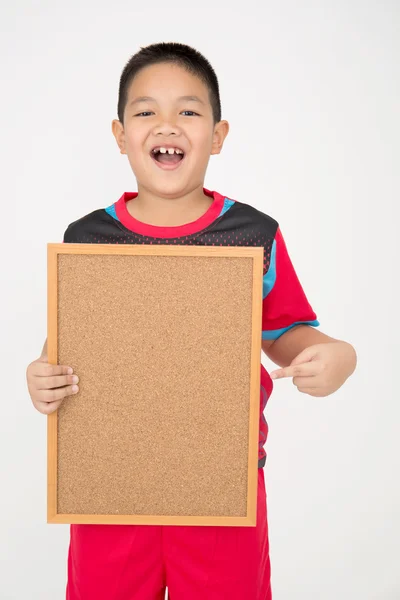 Aziatische jongetje bedrijf leeg houten bord in sport uniform — Stockfoto