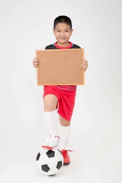 Piccolo asiatico ragazzo holding vuoto legno bordo in sport uniforme — Foto Stock