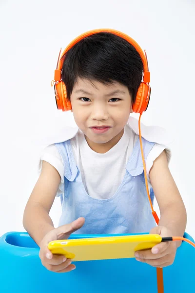 中国快乐男孩使用配有平板电脑耳机 — 图库照片