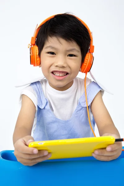 中国の幸せな男の子を使用してタブレット コンピューターのヘッドフォンで — ストック写真