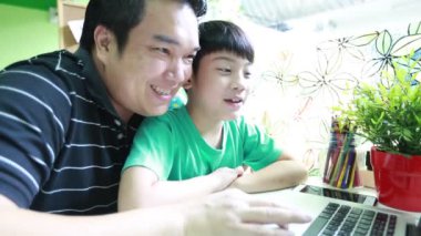 Mutlu Asya baba ve oğlu dizüstü bilgisayarda internette tarama vardır .