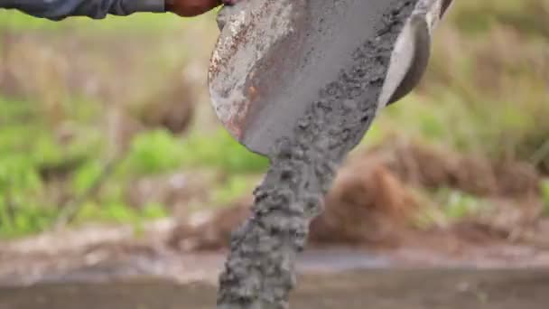 Неизвестные строители наливают бетонную смесь из бетоносмесителя . — стоковое видео