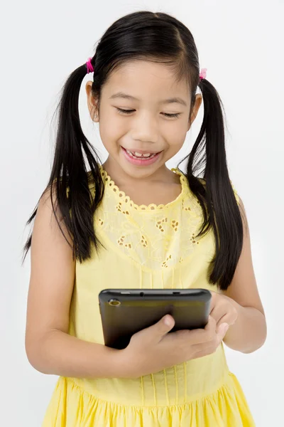 Little asian girl smiles with tablet computer — Stock Photo, Image