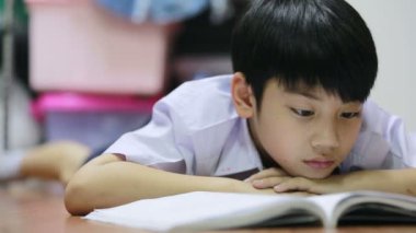 Asya sevimli çocuk evde yerdeki kitap okur.
