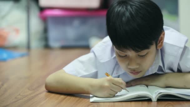 Asian cute boy reads the book on the floor at home. — Stock Video