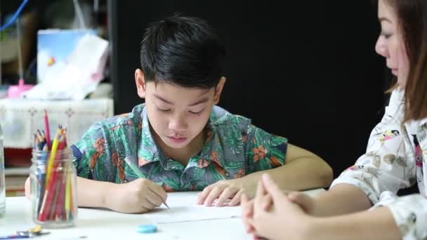 Мама заставляет своего сына делать домашнюю работу в школе — стоковое видео