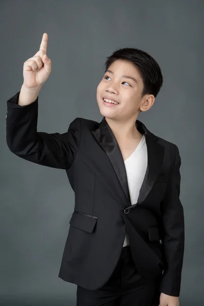 Little asian boy in black suit point up — Stock Photo, Image