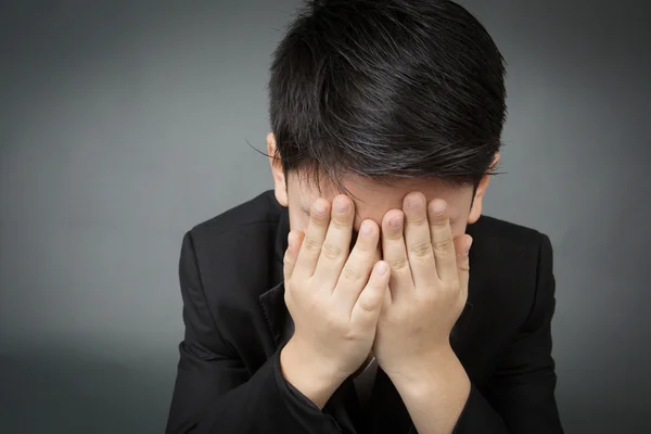 Little asian boy in black suit upset, depression face — Stock Photo, Image