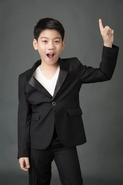 Little asian boy in black suit point up — Stock Photo, Image