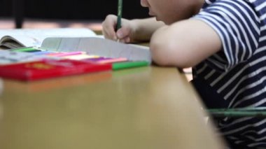 Küçük bir Asyalı çocuk renkli kalemle resim kapat