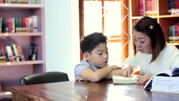 Leyendo con la maestra - un niño de primaria le lee en voz alta a su maestra — Vídeos de Stock