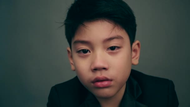 Портрет азиатского ребенка плачущего и сердитого на сером фоне — стоковое видео