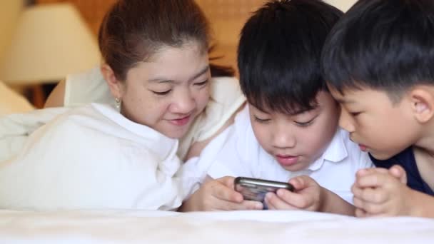 Aziatische en gelukkige familie spelen op Tablet PC, lacht, tot op bed. — Stockvideo