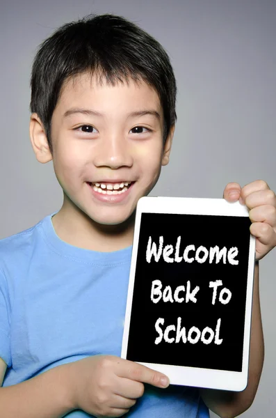 Pequeño asiático chico sonríe con tablet ordenador con vuelta a Schoo — Foto de Stock