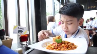 küçük Asyalı çocuk gülümsemek yüz ile restoranda spagetti yemek