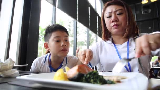 Glad familj mor och son äter tillsammans med leende ansikte — Stockvideo