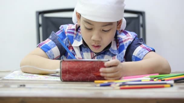 Pequeño asiático chico buscando celular y dibujo  . — Vídeos de Stock