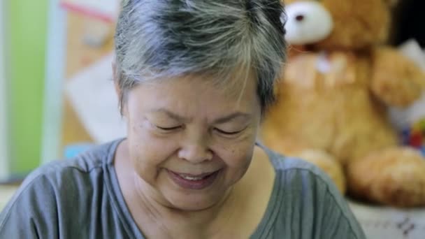 Feliz asiático senior mujer sonriendo en frente de cámara . — Vídeo de stock