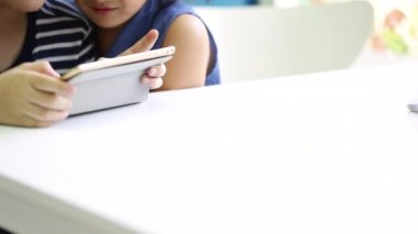 Tablet bilgisayar ve küçük kız birlikte oynayan küçük Asya çocuk