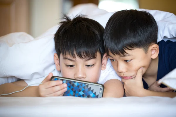 Niños preescolares serios jugando en el teléfono inteligente juntos —  Fotos de Stock