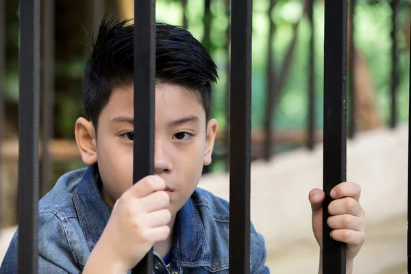 Aziatische jongen Hand in de gevangenis kijkt uit het raam — Stockfoto