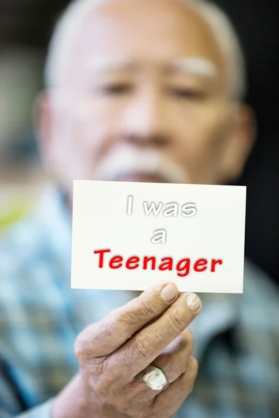 Asian Old man shows his card with I was a teenager Text — Stock Photo, Image