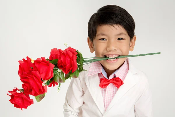 Kleiner asiatischer Junge im Vintage-Anzug mit roter Rose — Stockfoto