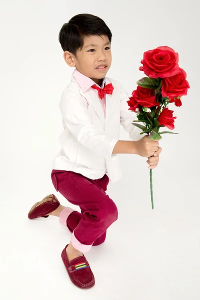 Piccolo ragazzo asiatico in abito vintage con rosa rossa — Foto Stock