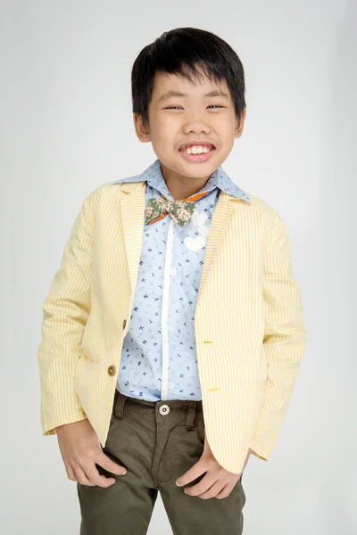 Маленький азиатский мальчик в винтажном костюме с улыбкой на лице — стоковое фото