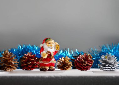 Noel ağacı süslemeleri çam kozalakları, Noel Baba eski oyuncakları, üzerinde kopyası olan gri bir arka plan. 