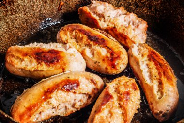 Yanmış tavada altı yanmış Alman sosisi.