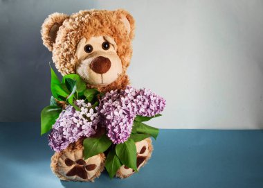 Bir buket leylaklı oyuncak ayı.