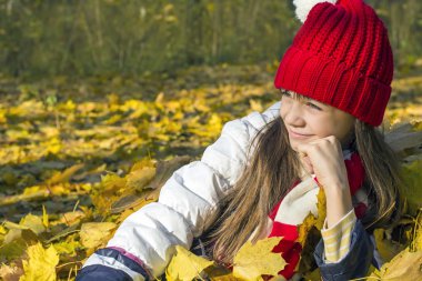 Kırmızı bere yalan güzel kız sonbahar yaprakları ve mesafe, içine görünüm gülümseyen