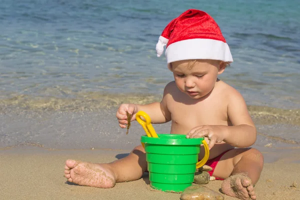 Noel Baba sahilde bir kap içinde küçük bir çocuk