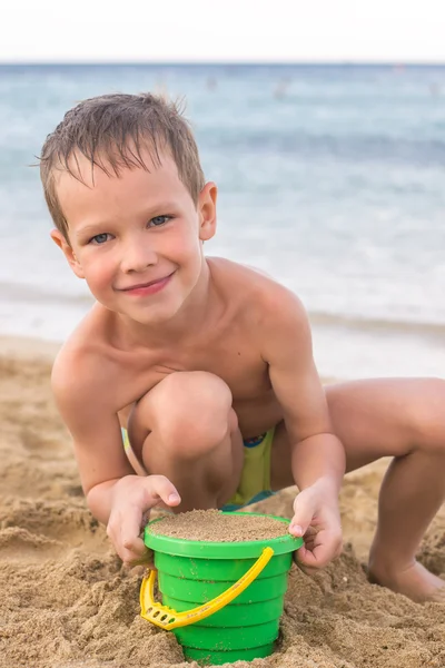 Pequeño niño en la orilla del mar jugando con arena —  Fotos de Stock