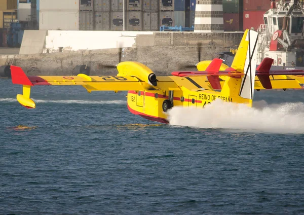 Aviões de combate a incêndios que recolhem água do mar para extinguir um incêndio florestal. — Fotografia de Stock