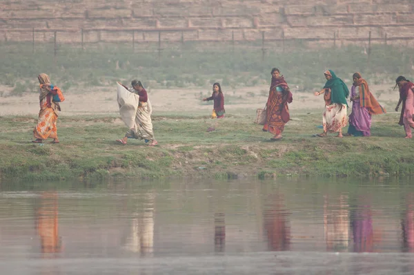 Indian women walking along a riverside in the Yamuna River. — Stock Photo, Image
