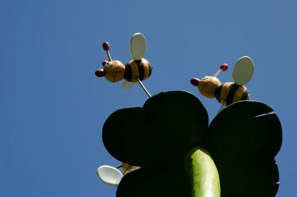 Escultura que representa una flor y dos abejas. —  Fotos de Stock