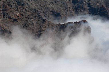 Volkanik bir kraterin uçurumları ve bulut denizi.