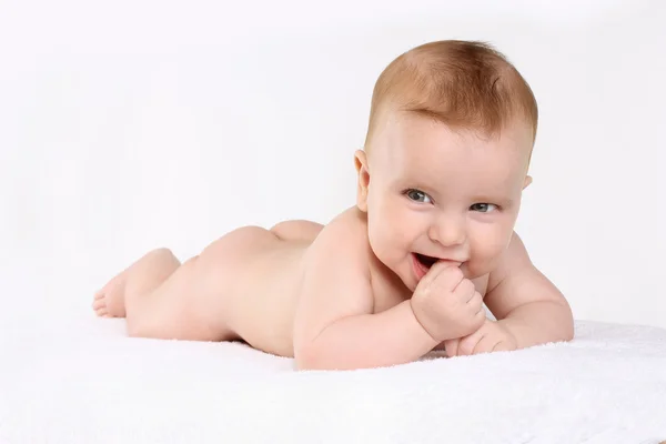 赤ちゃんの指を噛んで彼の胃の上に横たわる — ストック写真