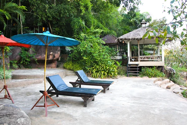 Two empty chairs under umbrella on river in Thailand — Stock Photo, Image