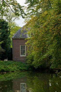 Rhijnauwen kalesinin yan görüntüsü Bunnik 'teki ağaçların yanında Utrecht iline bağlı bir köy.