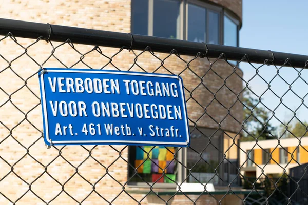 Sign attached to a fence with the Dutch text \'no entry for unauthorized persons, article 461 penal code\'