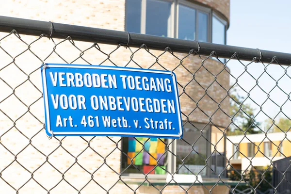 Sign attached to a fence with the Dutch text \'no entry for unauthorized persons, article 461 penal code\'